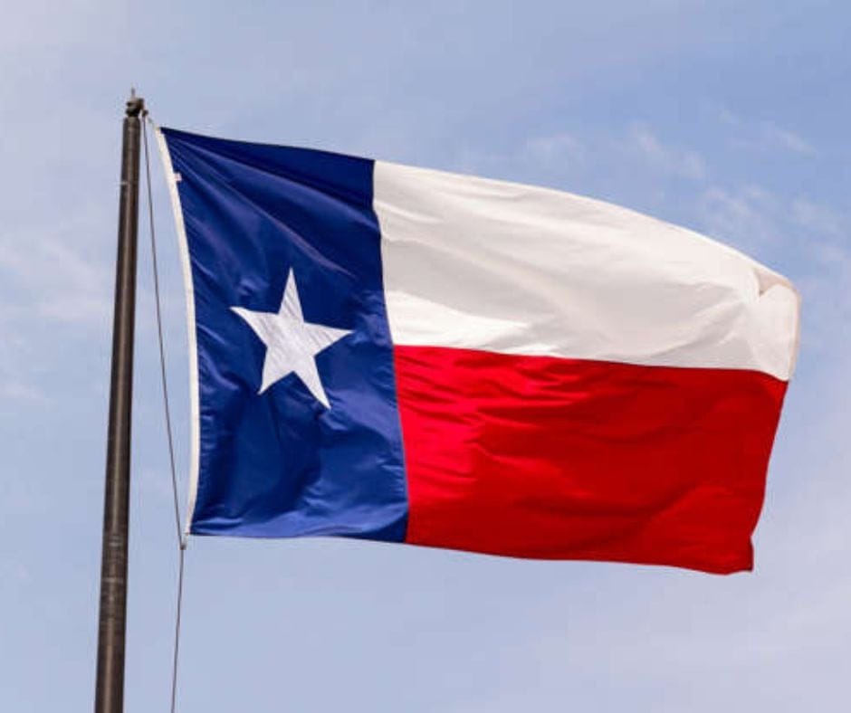 The flag of Texas hoisted to a pole and flying.